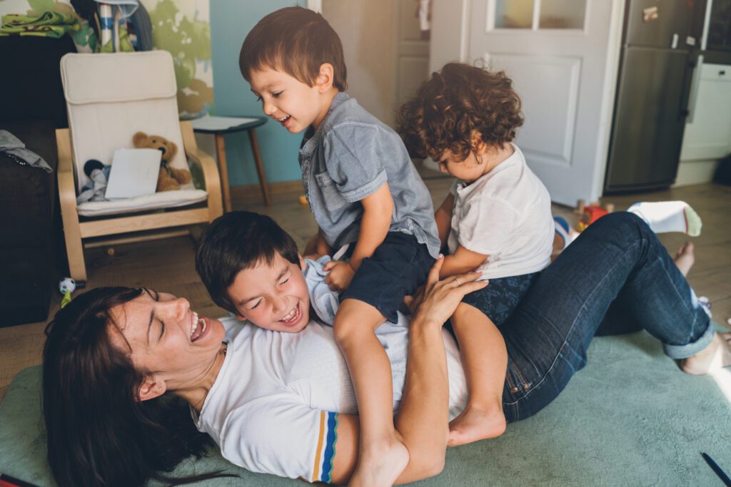 Mother and three boys playing