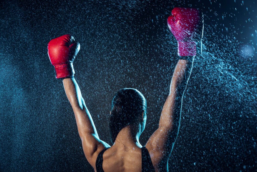 Back view of boxer in red boxing gloves showing yes gesture